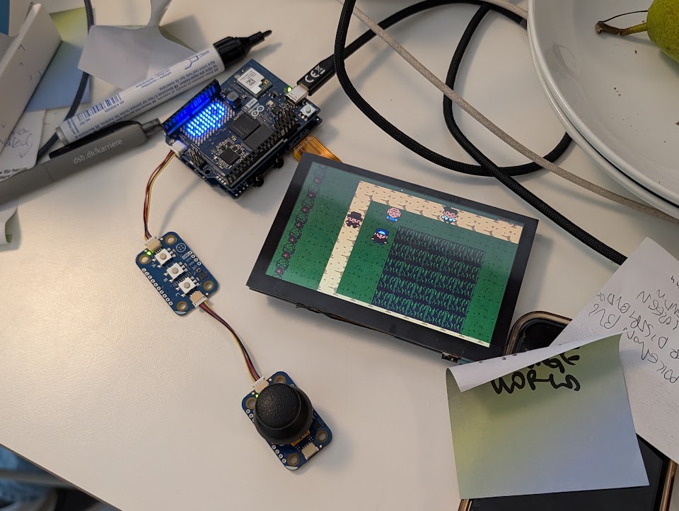 Una consola portátil en funcionamiento: juego, pantalla, joystick y hardware Arduino.